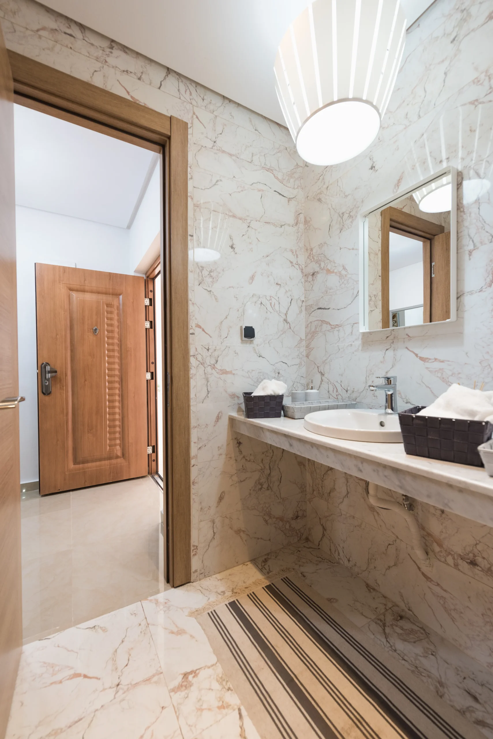 Salle de bain moderne avec marbre, lavabo et miroir appartement à Oujda