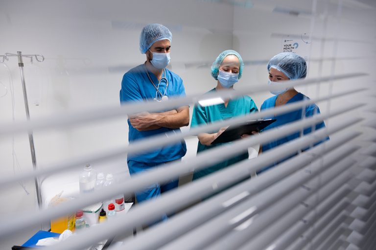 Équipe médicale en discussion dans une salle de consultation clinique moderne