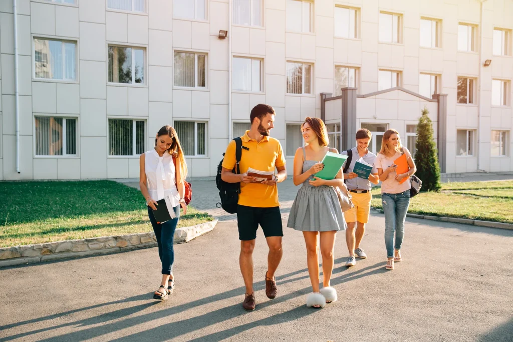 Groupe d’étudiants marchant sur un campus universitaire moderne et lumineux