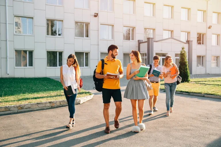 Groupe d’étudiants marchant sur un campus universitaire moderne et lumineux