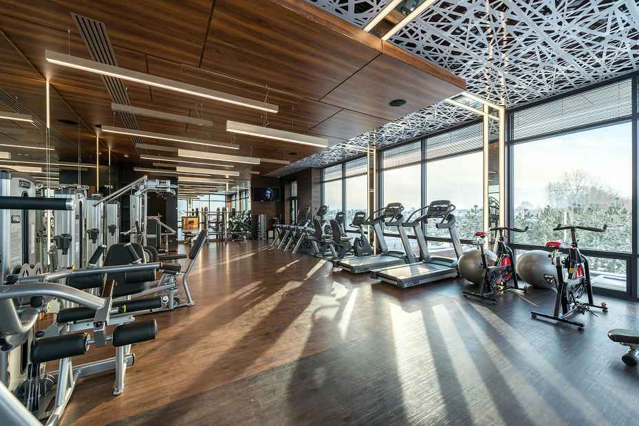 Salle de sport moderne avec machines de fitness et grandes baies vitrées