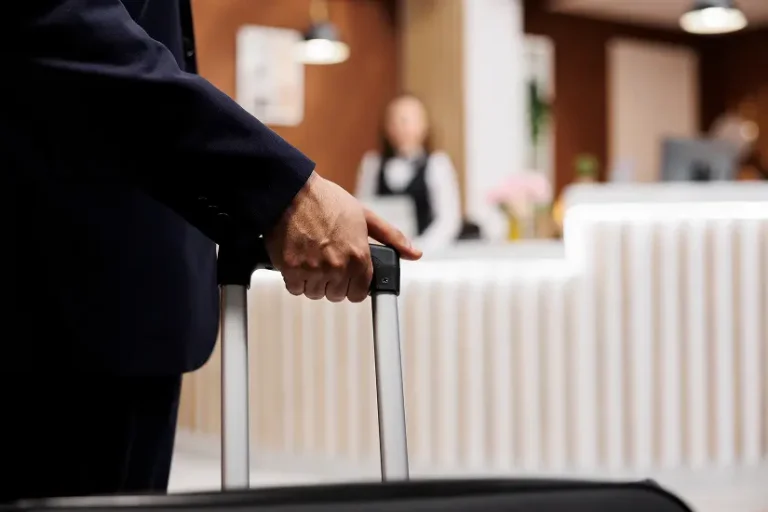 Client arrivant à la réception d’un hôtel avec valise pour check-in
