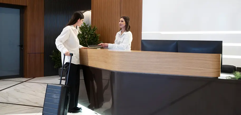 Cliente accueillie à la réception d’un hôtel moderne avec comptoir design