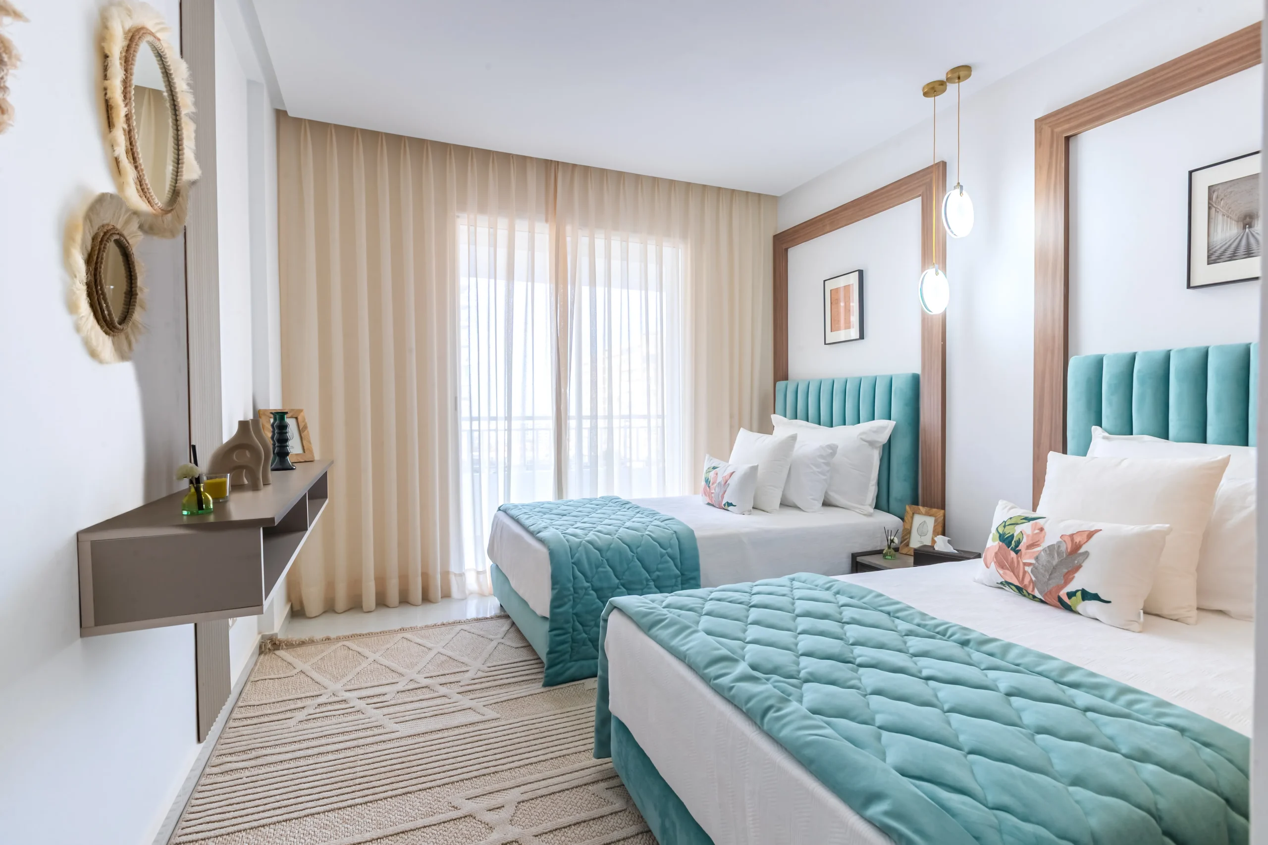 Chambre enfants lumineuse avec deux lits simples, têtes de lit turquoise et décoration douce