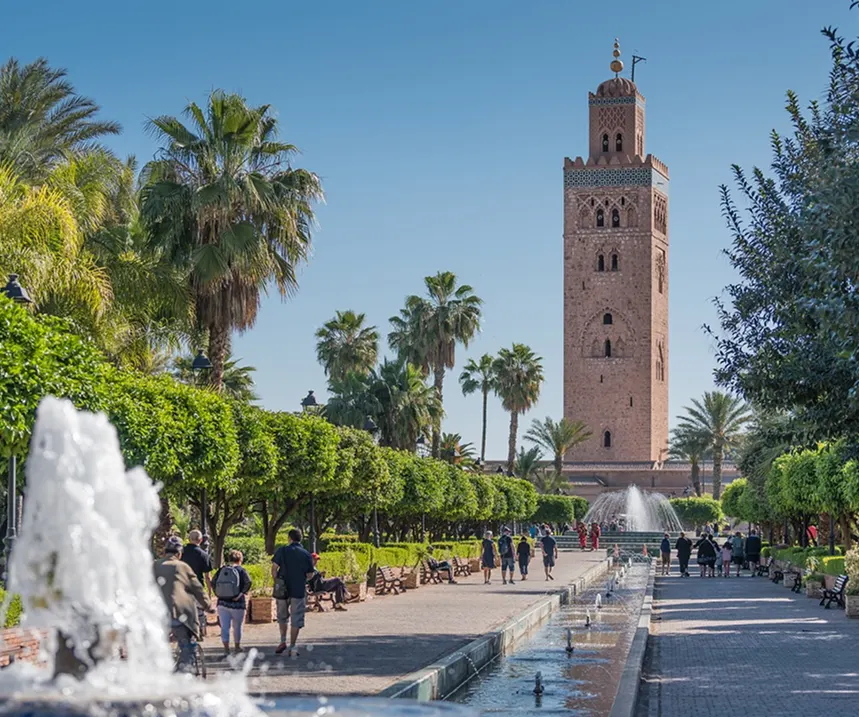 Vue de la mosquée Koutoubia à Marrakech entourée de palmiers et de jardins avec fontaines
